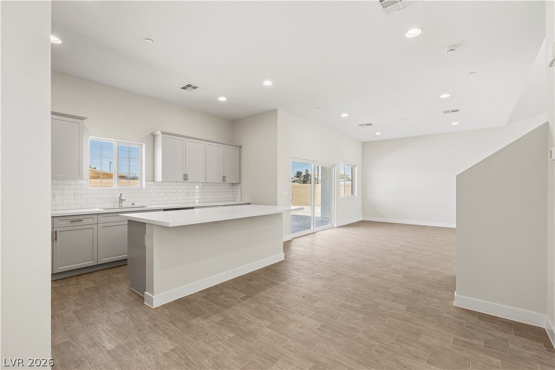 An open layout connects the kitchen to the living spaces over smooth tile flooring.