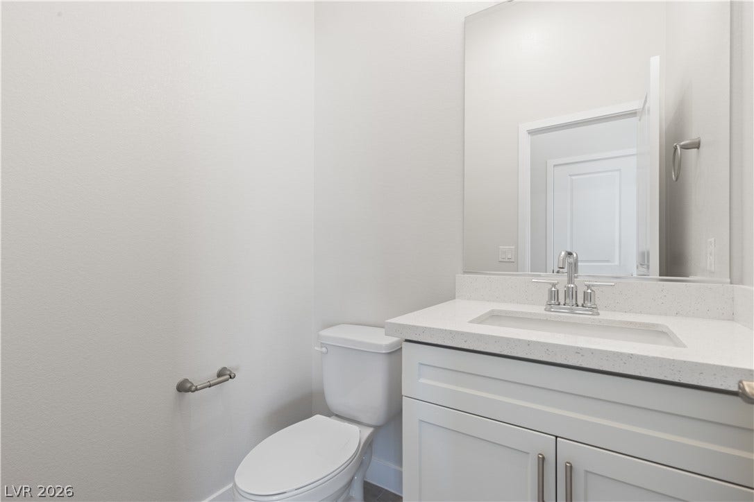 A modern vanity with a stone countertop serves this clean powder room.