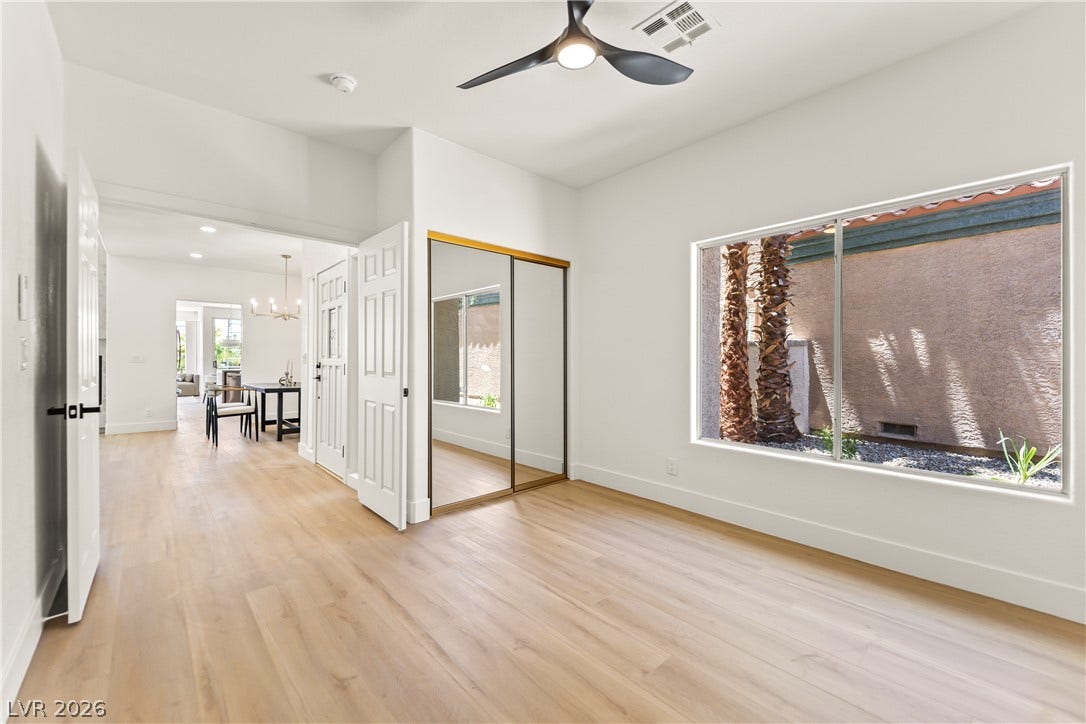 8921 Diamond Falls Drive, Las Vegas, NV 89117 Blonde hardwood floors extend through this room, complemented by a modern ceiling fan and mirrored closet doors.