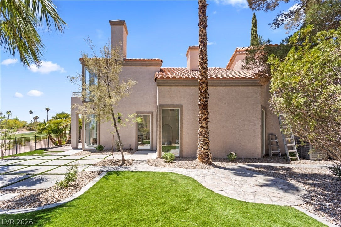 8921 Diamond Falls Drive, Las Vegas, NV 89117 Lush landscaping and stone pathways lead to this appealing stucco residence, framed by mature trees and bright skies.
