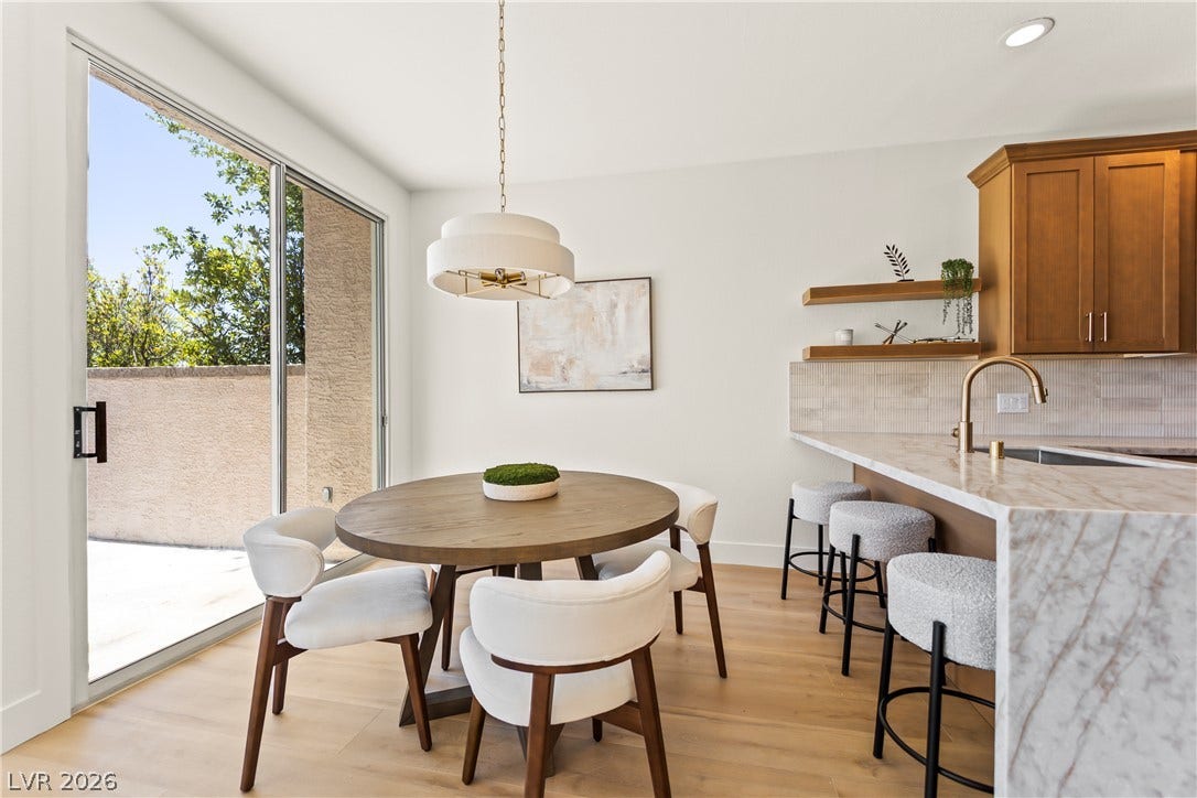 8921 Diamond Falls Drive, Las Vegas, NV 89117 A well-appointed kitchen-dining area offers seamless outdoor access through a glass sliding door.