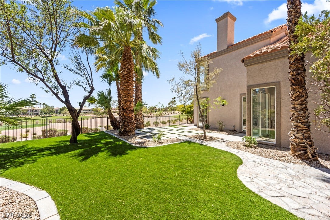 8921 Diamond Falls Drive, Las Vegas, NV 89117 A private yard with lush artificial turf and mature palms overlooks the serene golf course.