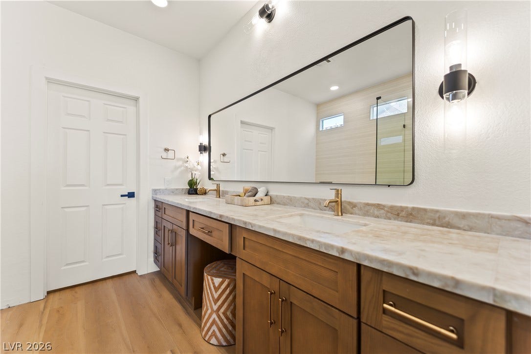 8921 Diamond Falls Drive, Las Vegas, NV 89117 Double vanity with exquisite marble countertops and modern gold fixtures provides ample space for personal routines.