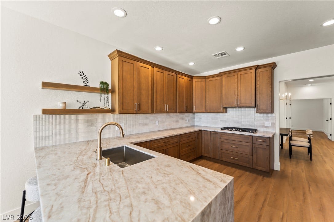 8921 Diamond Falls Drive, Las Vegas, NV 89117 Gleaming stone countertops and rich cabinetry define this culinary space, ready for gourmet meals.