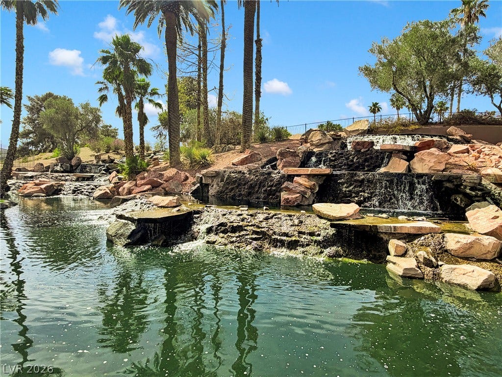 8921 Diamond Falls Drive, Las Vegas, NV 89117 A tranquil oasis with cascading waterfalls, rock formations, and lush palm trees.