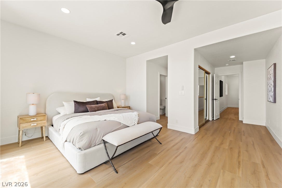 8921 Diamond Falls Drive, Las Vegas, NV 89117 Natural light illuminates the hardwood flooring, creating an inviting ambiance in this spacious sleeping area.