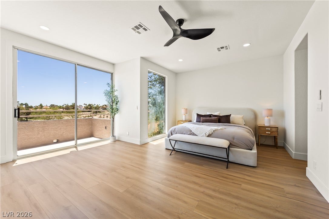 8921 Diamond Falls Drive, Las Vegas, NV 89117 Floor-to-ceiling glass doors and a picture window illuminate this bedroom with natural light and views.