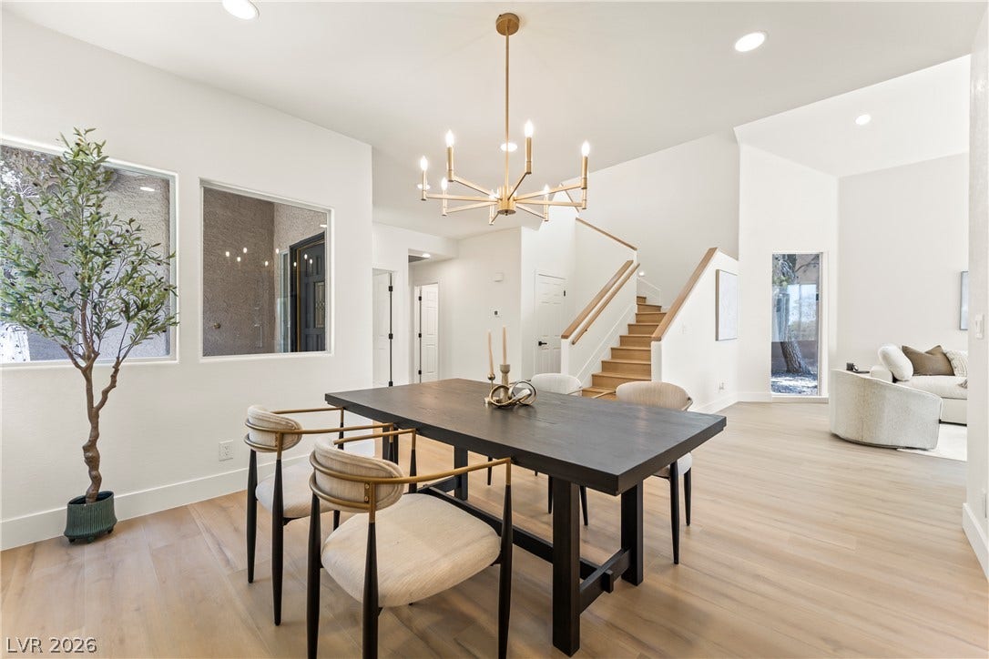 8921 Diamond Falls Drive, Las Vegas, NV 89117 A well-appointed dining space flows seamlessly into a contemporary living area, featuring light wood floors and high ceilings.