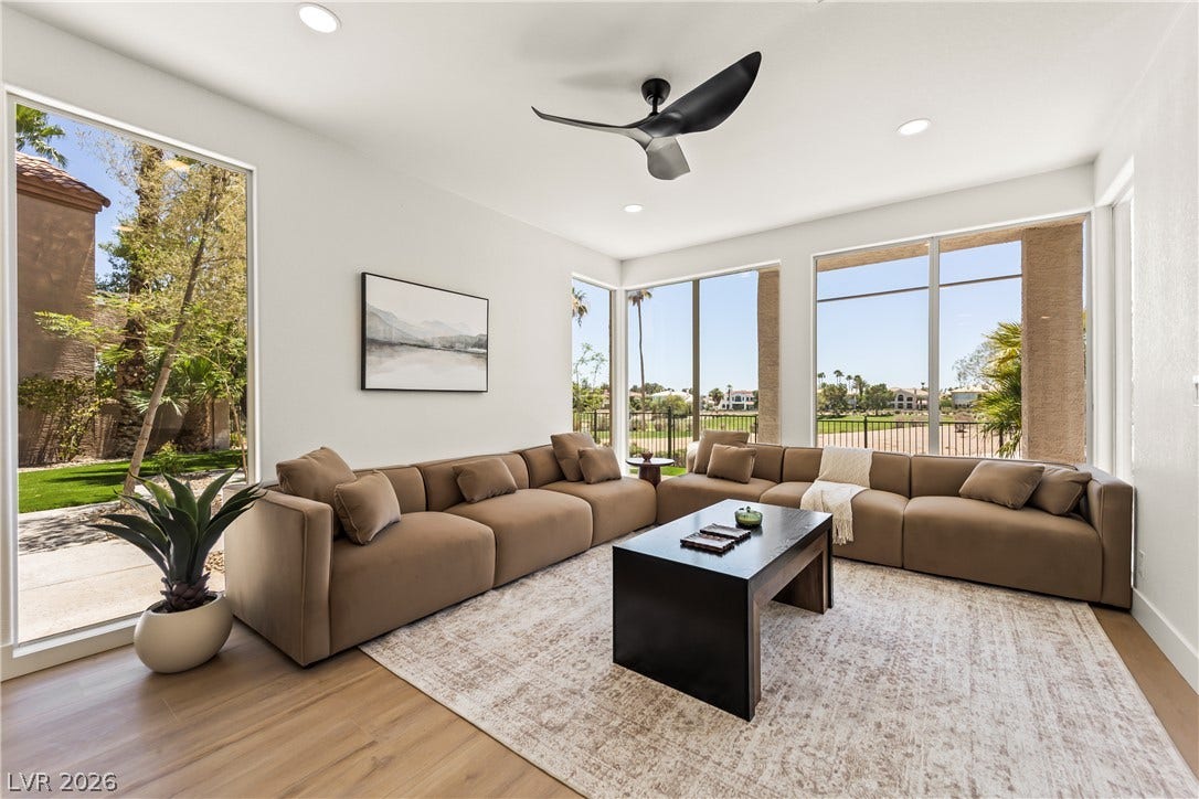 8921 Diamond Falls Drive, Las Vegas, NV 89117 Floor-to-ceiling windows offer captivating outdoor views of a well-maintained green landscape.