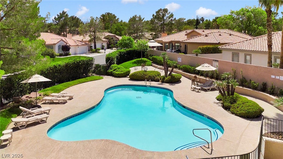 8921 Diamond Falls Drive, Las Vegas, NV 89117 An inviting community pool awaits, nestled amongst lush landscaping and residential charm.