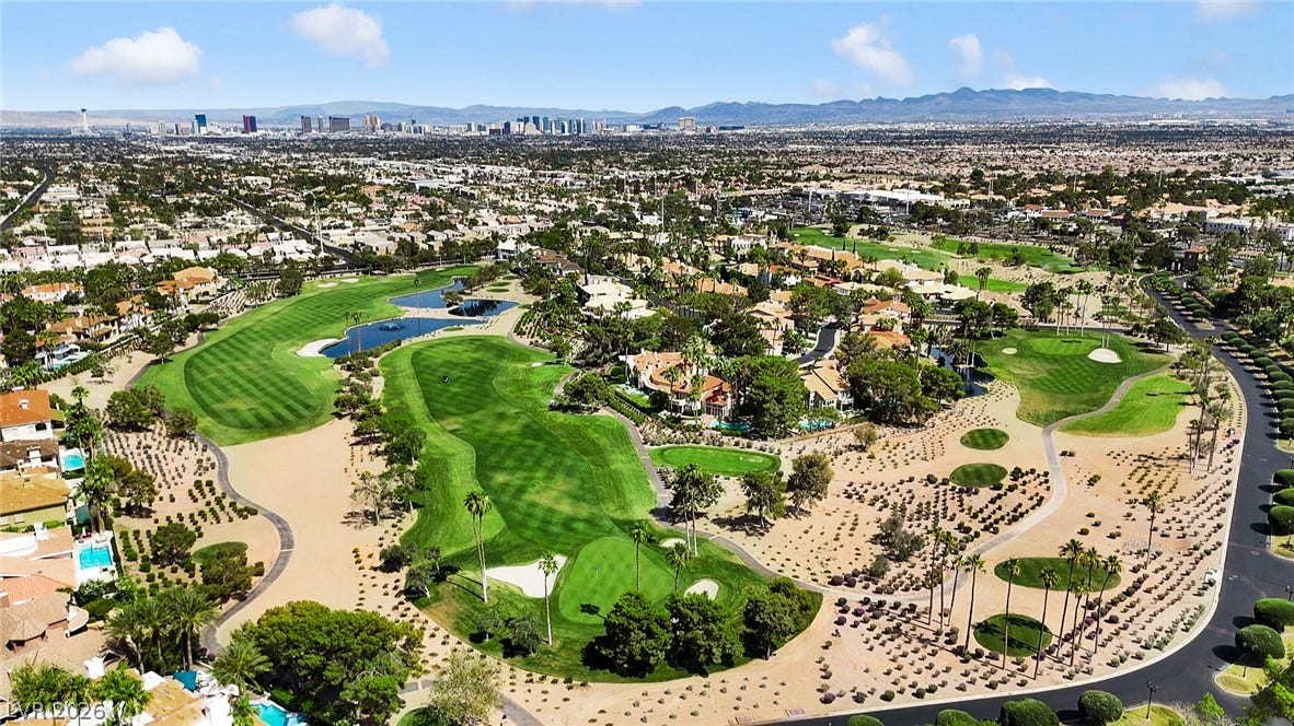 8921 Diamond Falls Drive, Las Vegas, NV 89117 An aerial perspective reveals a luxurious golf course community with desert landscaping and cityscape views.