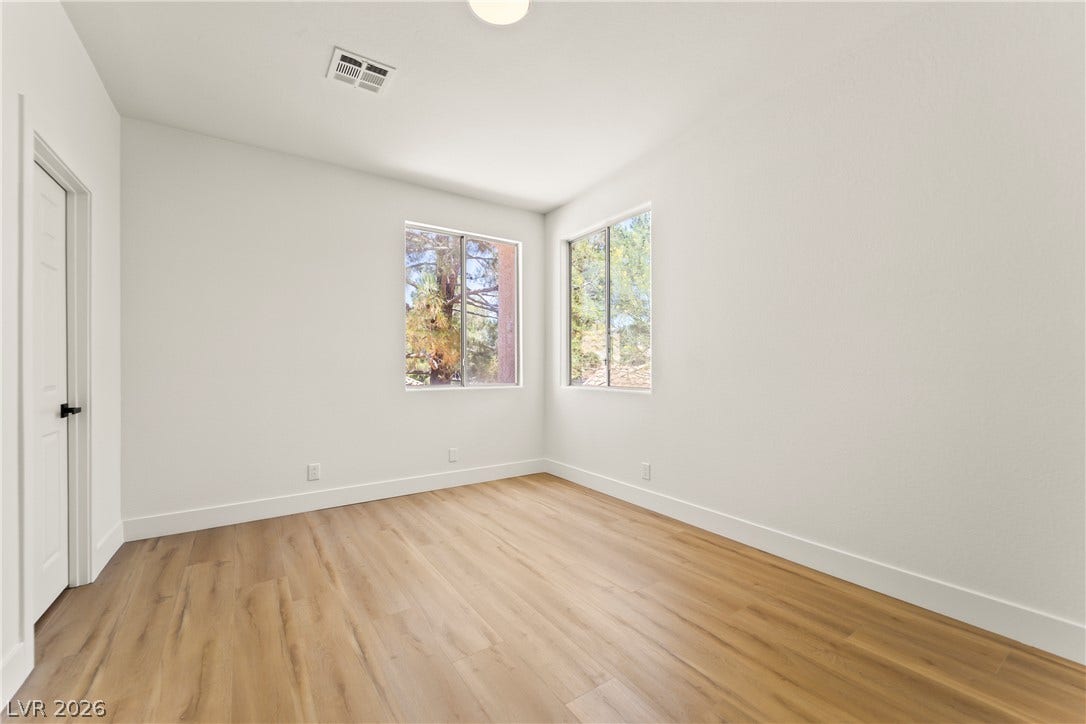 8921 Diamond Falls Drive, Las Vegas, NV 89117 Natural light floods this room, highlighting the warm wood-look flooring.