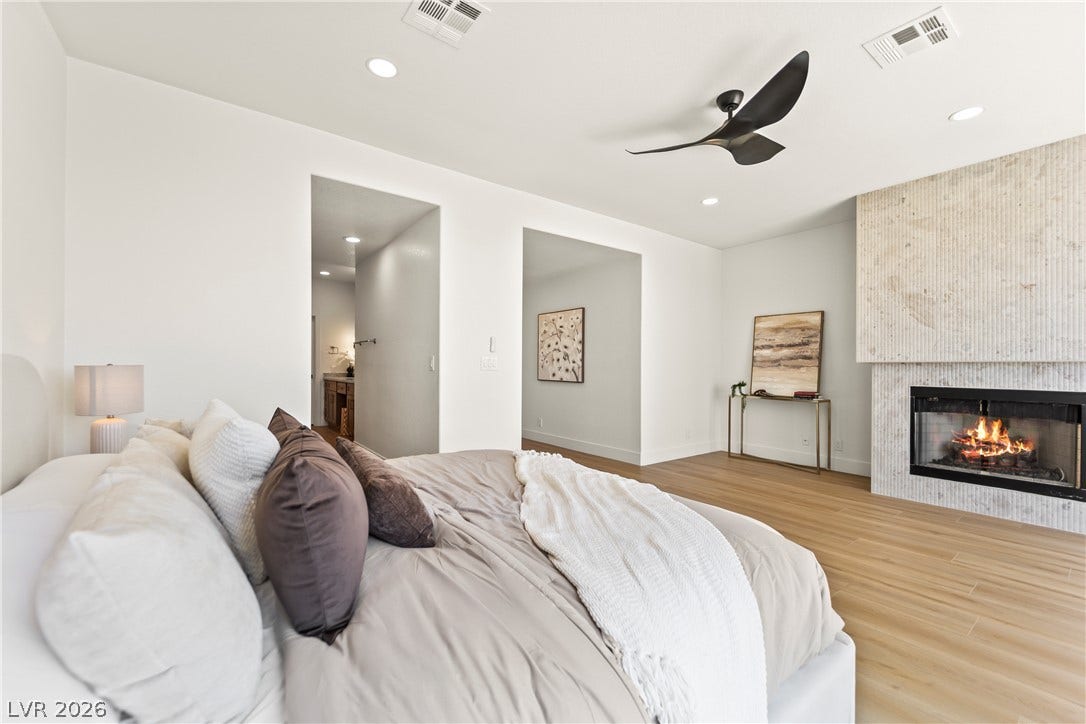 8921 Diamond Falls Drive, Las Vegas, NV 89117 A striking fireplace with a tiled surround elevates this inviting bedroom.