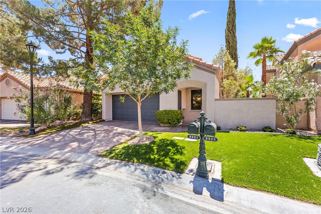 8921 Diamond Falls Drive, Las Vegas, NV 89117 Front facade with a well-manicured lawn and a spacious driveway welcomes residents and guests.