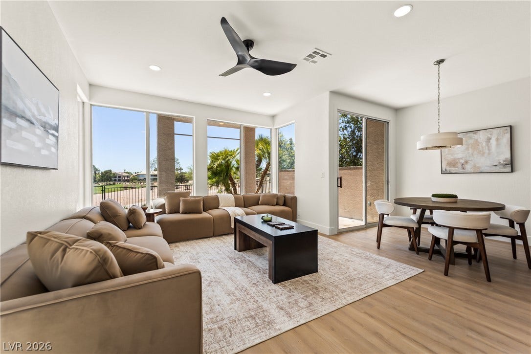 8921 Diamond Falls Drive, Las Vegas, NV 89117 Floor-to-ceiling windows bathe this inviting living and dining space in natural light, showcasing picturesque outdoor views.