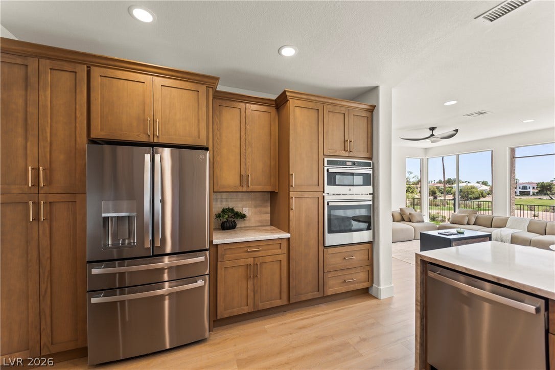 8921 Diamond Falls Drive, Las Vegas, NV 89117 A well-appointed kitchen showcasing contemporary appliances and custom cabinetry opens to a spacious living area.