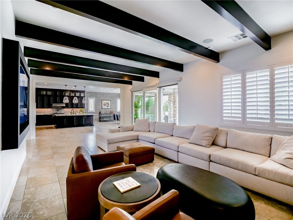 12013 Tramonto Avenue, Las Vegas, NV 89138 Striking dark ceiling beams contrast with light tile flooring in this open living space.