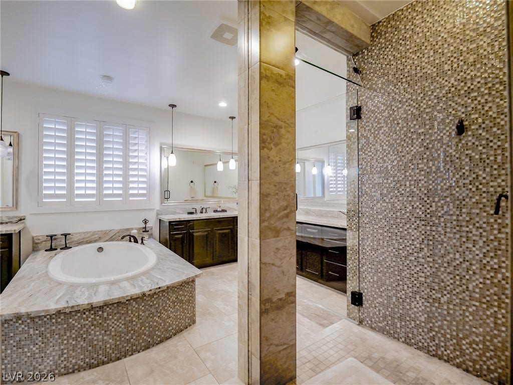 12013 Tramonto Avenue, Las Vegas, NV 89138 A stone soaking tub and walk-in glass shower define this main bath.