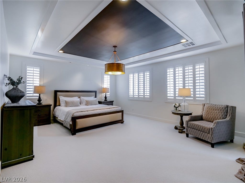 12013 Tramonto Avenue, Las Vegas, NV 89138 An elegant tray ceiling with custom inset detailing anchors this bedroom suite.