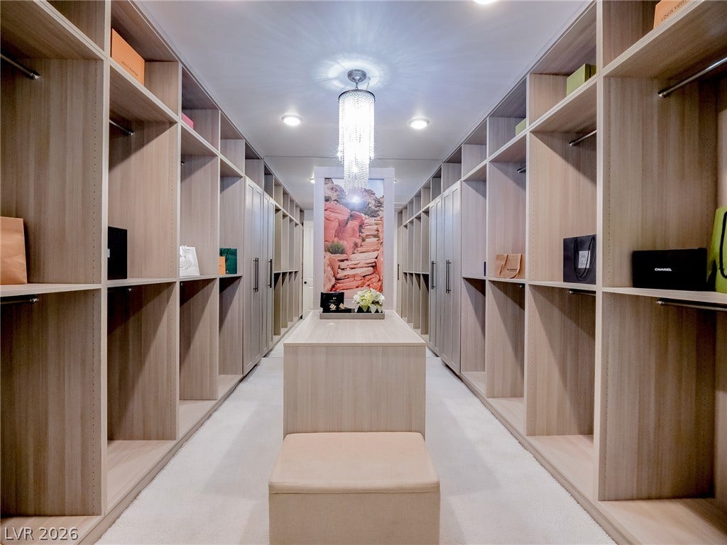 12013 Tramonto Avenue, Las Vegas, NV 89138 Custom floor-to-ceiling shelving and central storage island maximize space in this walk-in closet.