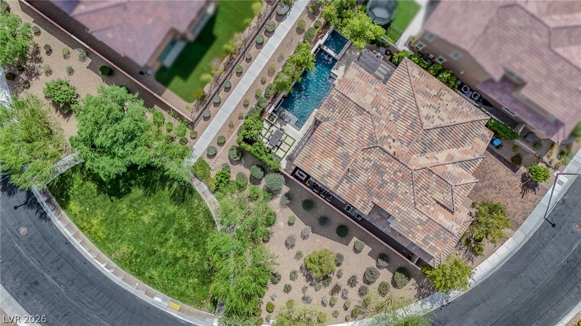 12013 Tramonto Avenue, Las Vegas, NV 89138 An aerial perspective captures the tiled roofline, private pool, and desert landscaping of this property.