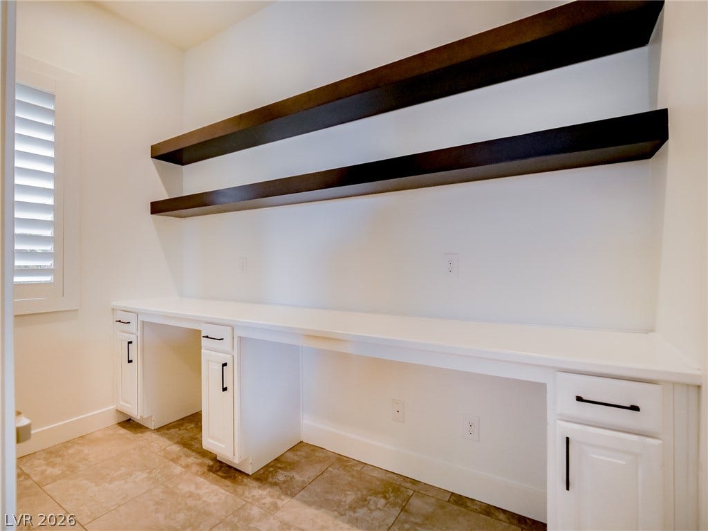 12013 Tramonto Avenue, Las Vegas, NV 89138 Functional built-in desks and floating shelves maximize storage in this versatile home office.