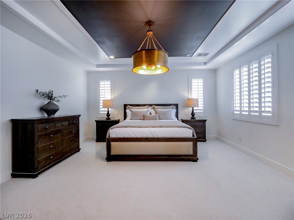 12013 Tramonto Avenue, Las Vegas, NV 89138 A dark inset tray ceiling crowns this spacious bedroom with elegant plantation shutters.