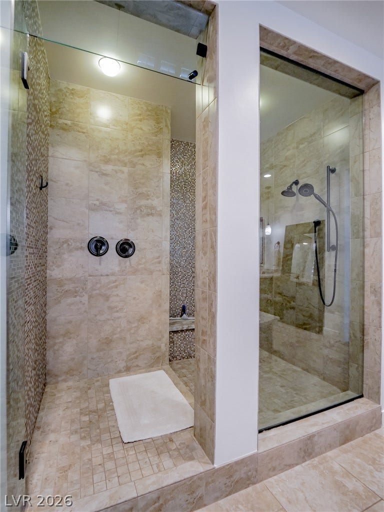 12013 Tramonto Avenue, Las Vegas, NV 89138 Fine stone tile and seamless glass panels frame this luxury walk-in shower design.