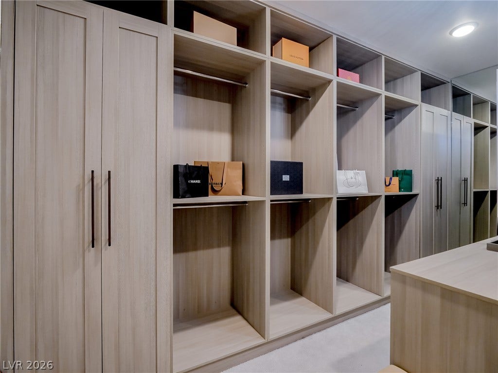 12013 Tramonto Avenue, Las Vegas, NV 89138 Custom floor-to-ceiling cabinetry and built-in shelving maximize organization within this spacious wardrobe.