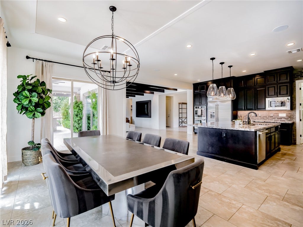 12013 Tramonto Avenue, Las Vegas, NV 89138 Stone tile floors and a soaring ceiling define this open-concept dining space and gourmet kitchen.