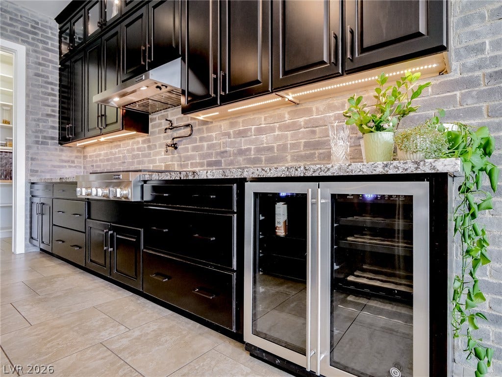 12013 Tramonto Avenue, Las Vegas, NV 89138 Dramatic dark cabinetry pairs beautifully with stone accents and sleek tile flooring.