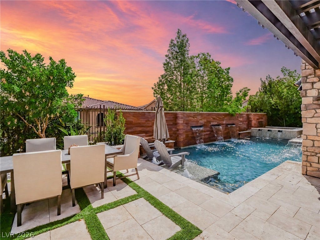 12013 Tramonto Avenue, Las Vegas, NV 89138 An inviting backyard oasis features a pristine swimming pool accented by elegant stone waterfalls.