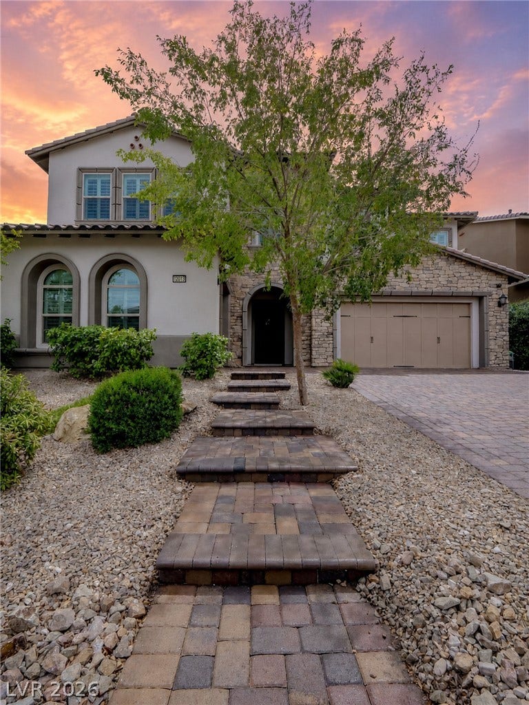 12013 Tramonto Avenue, Las Vegas, NV 89138 An inviting stone-accented exterior is complemented by a paved walkway and low-maintenance desert landscaping.