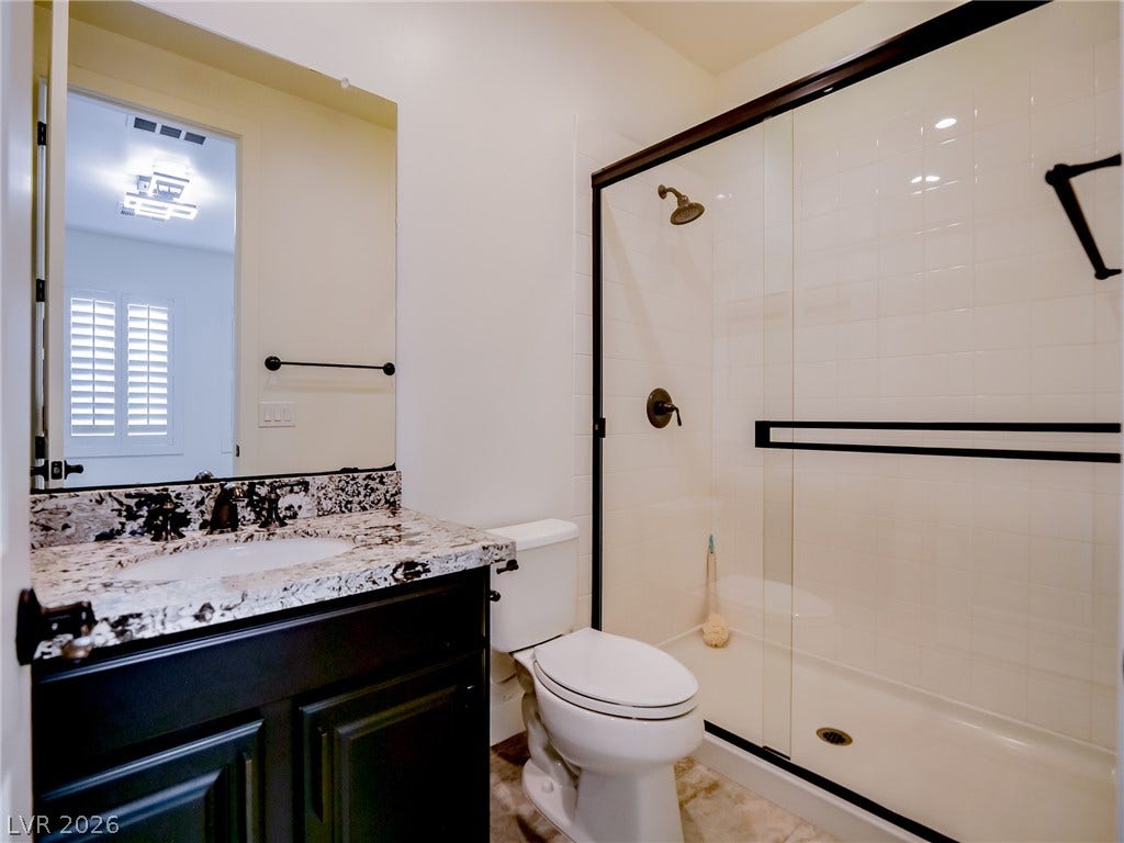 12013 Tramonto Avenue, Las Vegas, NV 89138 Modern vanity surfaces and a spacious glass-enclosed shower highlight this pristine bathroom.