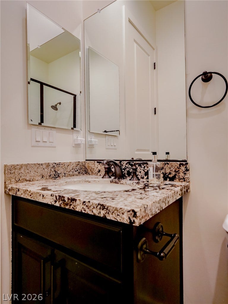 12013 Tramonto Avenue, Las Vegas, NV 89138 Polished stone counters elevate the clean design of this modern vanity area.