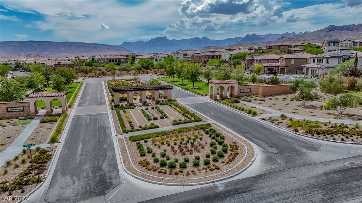 12013 Tramonto Avenue, Las Vegas, NV 89138 Dramatic mountain backdrops frame a beautifully landscaped gated community entrance with manicured islands.