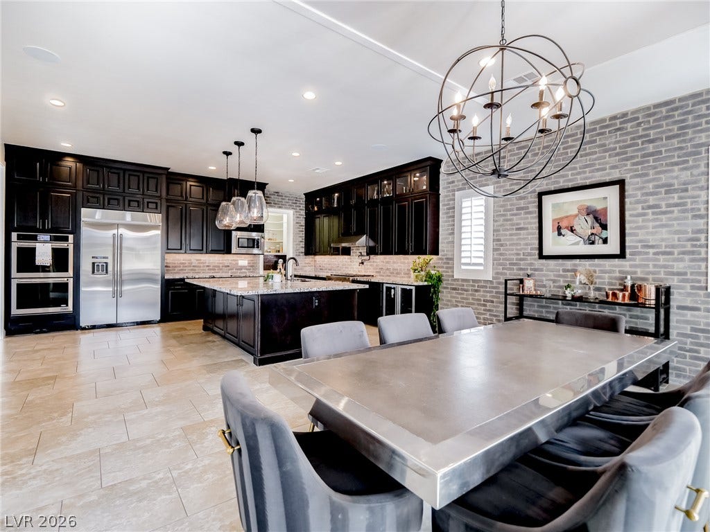 12013 Tramonto Avenue, Las Vegas, NV 89138 Exposed brick accents, tile flooring, and a expansive kitchen island anchor this open-concept space.