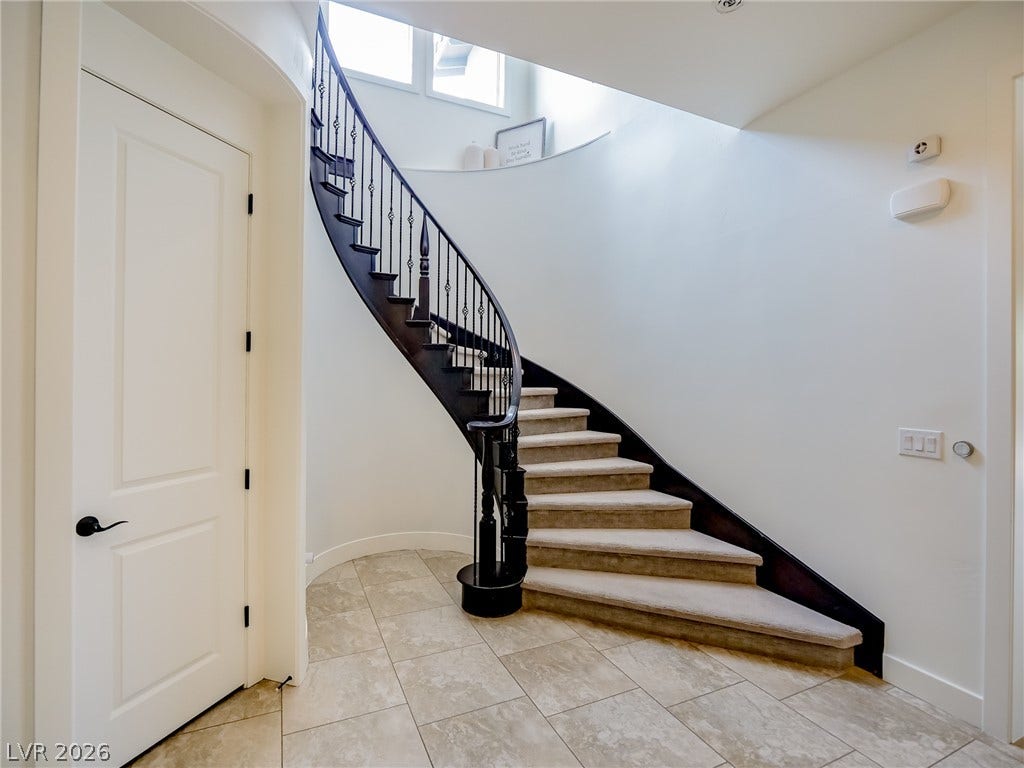 12013 Tramonto Avenue, Las Vegas, NV 89138 A sweeping curved staircase makes a dramatic architectural statement in this grand entrance foyer.