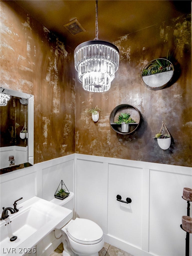 12013 Tramonto Avenue, Las Vegas, NV 89138 Dramatic textured walls contrast beautifully with classic white wainscoting in this elegant powder room.
