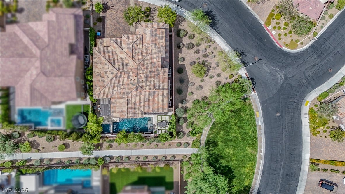 12013 Tramonto Avenue, Las Vegas, NV 89138 An aerial perspective showcases the tile roof and private pool nestled on a curved street.