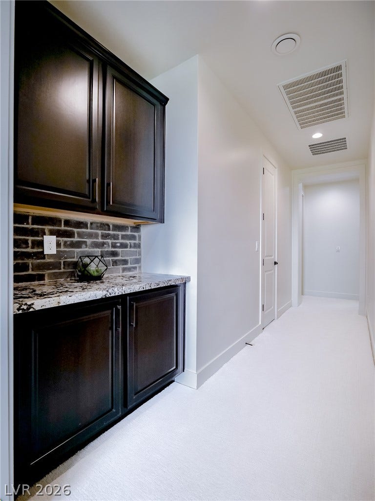 12013 Tramonto Avenue, Las Vegas, NV 89138 Custom cabinetry and polished stone counters flank a pristine hallway leading to private quarters.