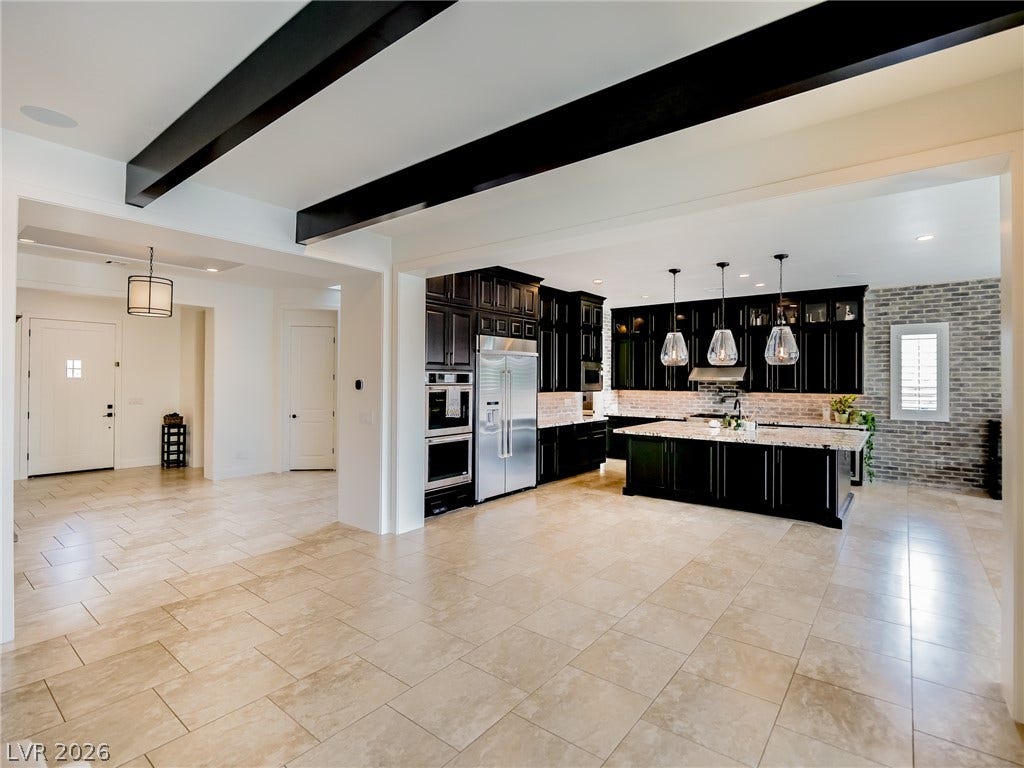 12013 Tramonto Avenue, Las Vegas, NV 89138 Exposed ceiling beams look over an open-concept layout leading into a modern kitchen.