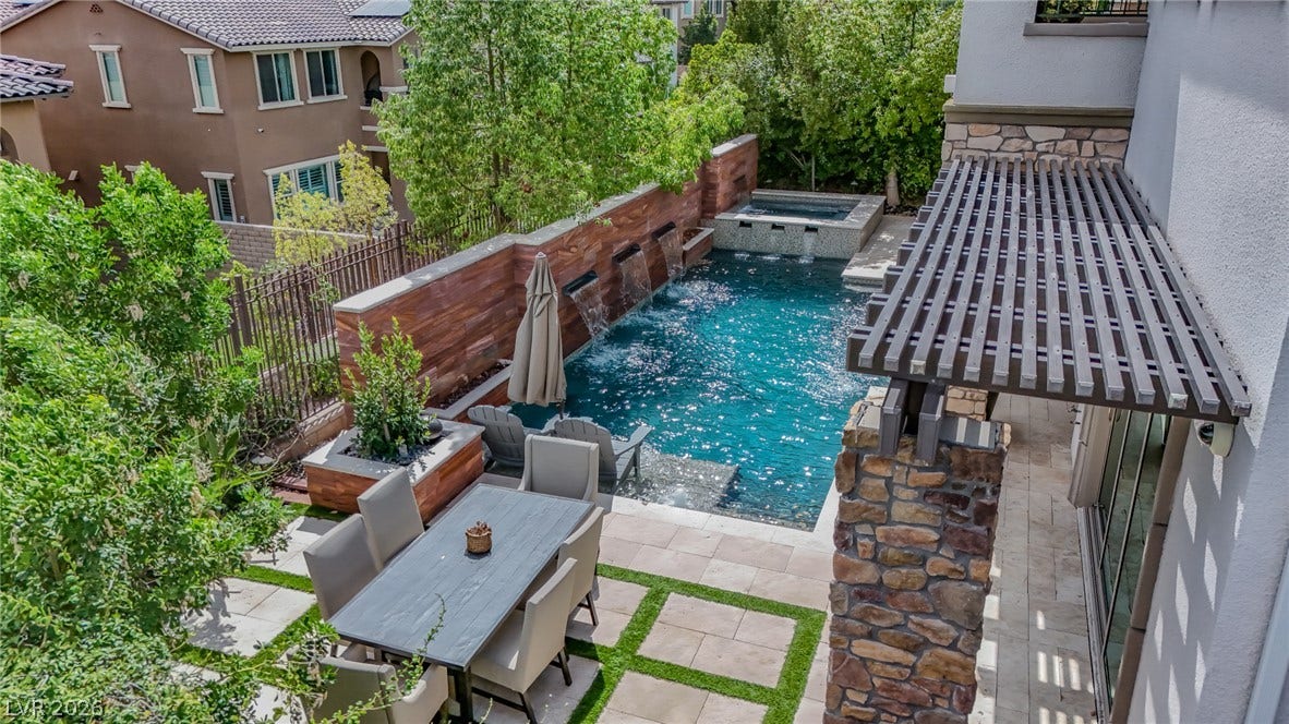 12013 Tramonto Avenue, Las Vegas, NV 89138 A private backyard oasis features a swimming pool with multiple waterfalls and an integrated spa.