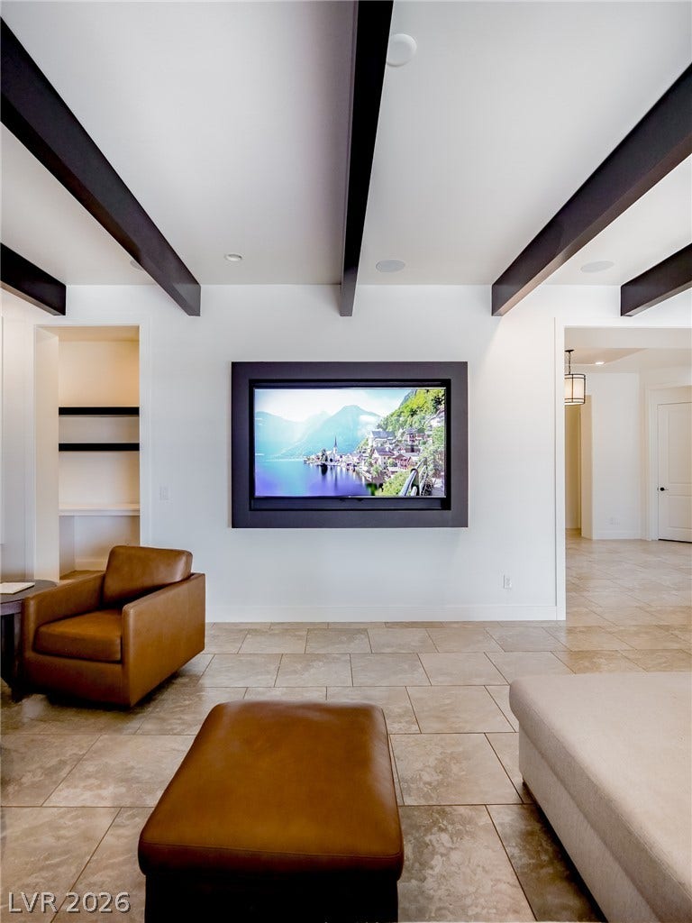 12013 Tramonto Avenue, Las Vegas, NV 89138 Striking dark ceiling beams contrast with light tile flooring in this open living space.