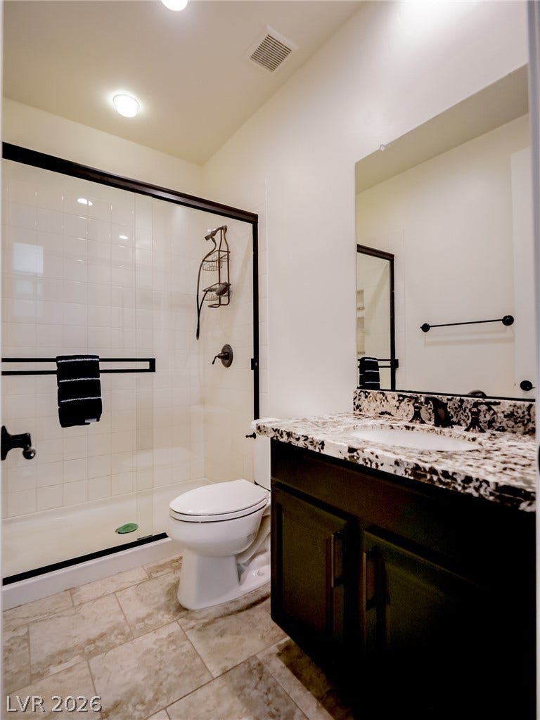 12013 Tramonto Avenue, Las Vegas, NV 89138 A classic tiled shower with glass doors sits adjacent to a granite-topped vanity.