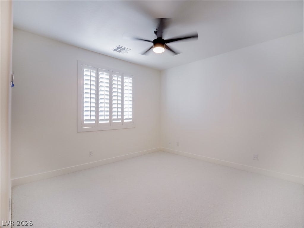 12013 Tramonto Avenue, Las Vegas, NV 89138 Plush carpeting and elegant plantation shutters complete this serene bedroom space.