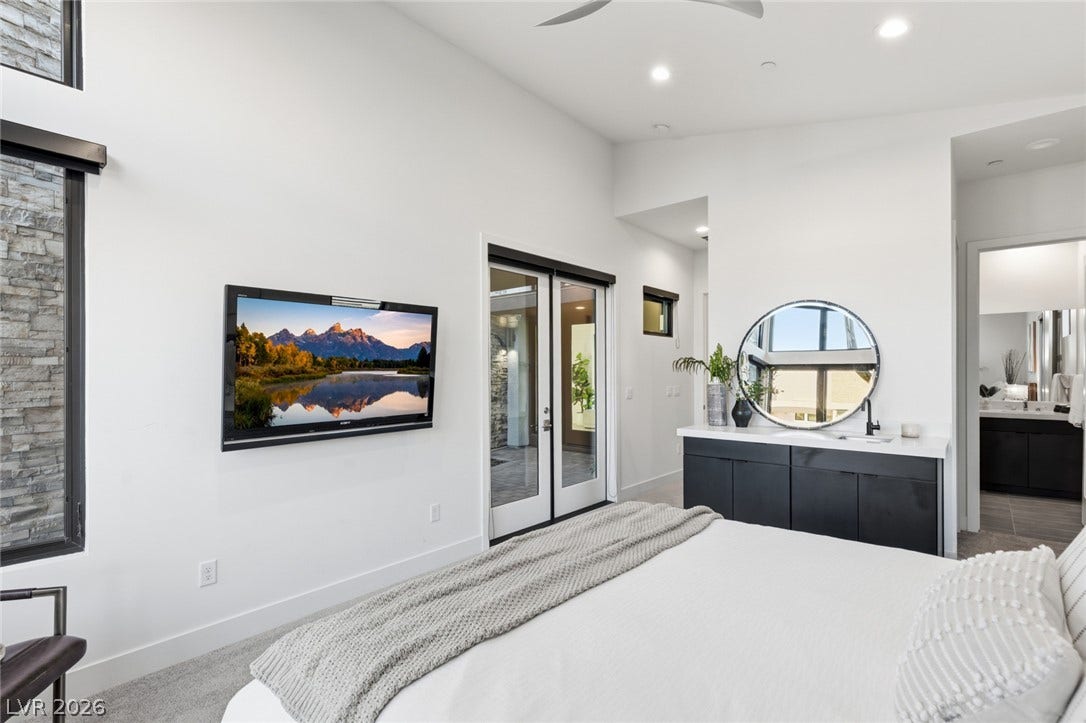 2208 Overlook Canyon Lane, Henderson, NV 89052 Crisp white walls and ample natural light illuminate this inviting primary bedroom suite.
