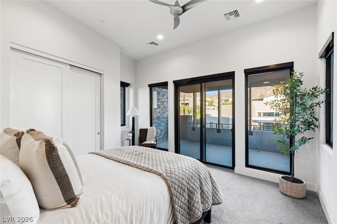 2208 Overlook Canyon Lane, Henderson, NV 89052 Floor-to-ceiling glass doors open to a generous outdoor balcony, perfect for serene mornings.