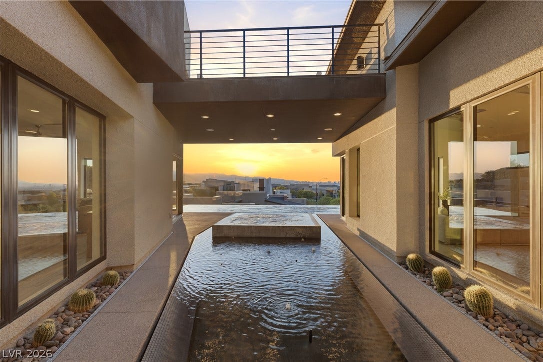 2208 Overlook Canyon Lane, Henderson, NV 89052 Sunset views over the mountains complement this modern home's exterior water feature and elevated balcony.