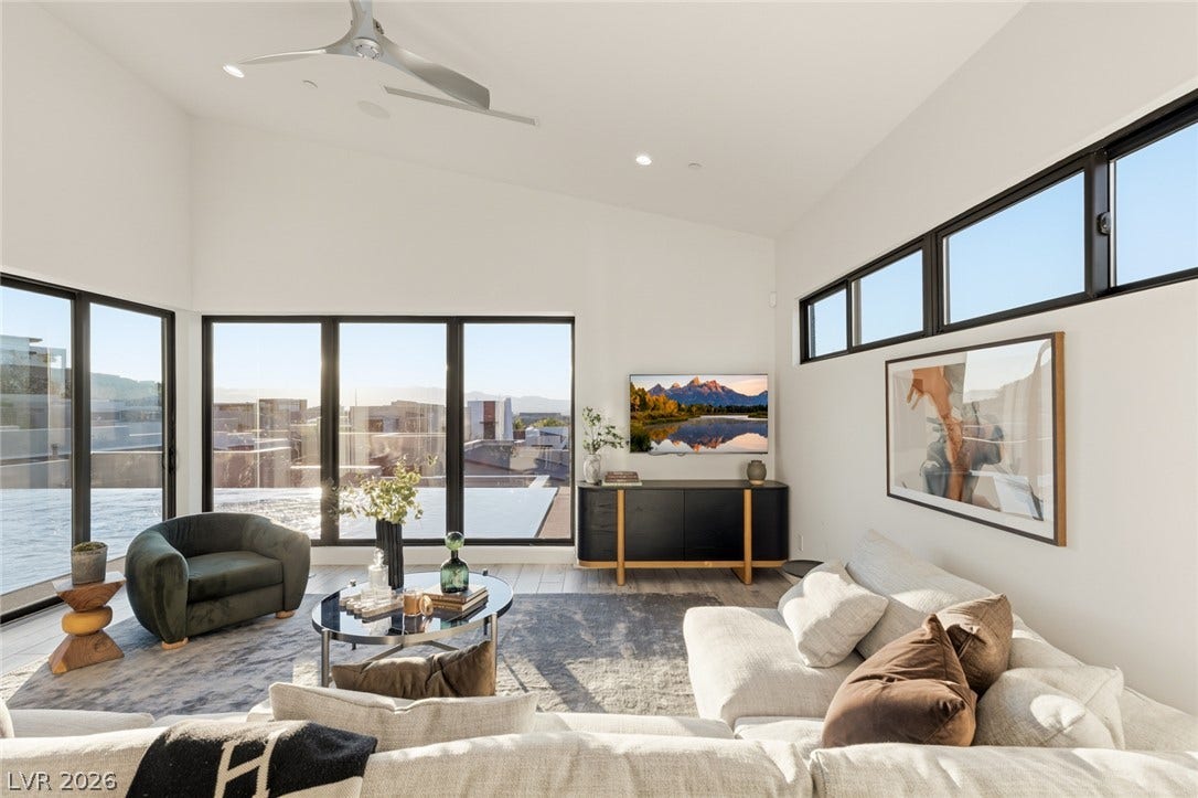 2208 Overlook Canyon Lane, Henderson, NV 89052 Floor-to-ceiling windows illuminate a spacious, open living area with clean lines and soaring ceilings.